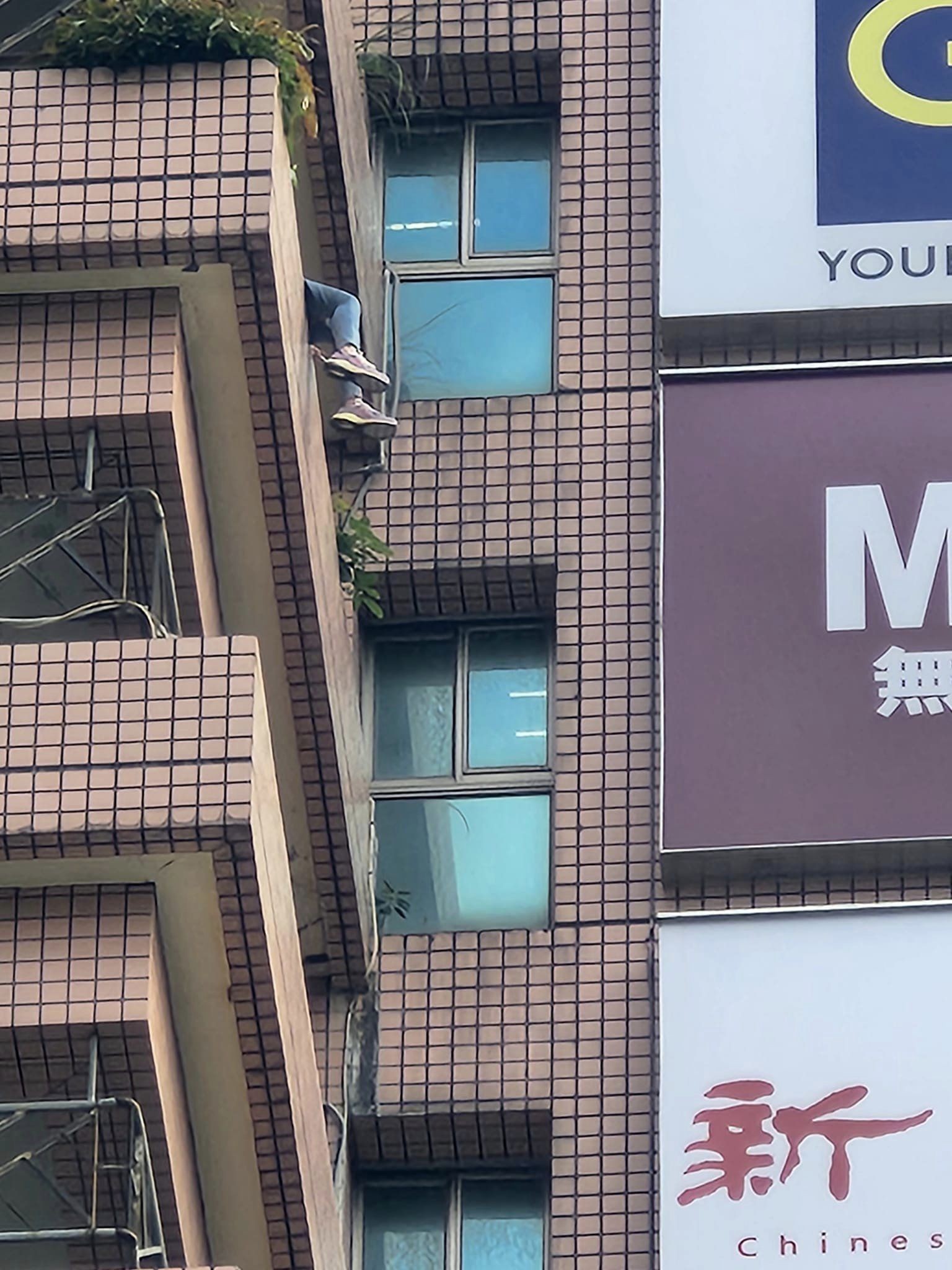 女子坐在10樓外牆。(圖/翻攝自爆料公社臉書)