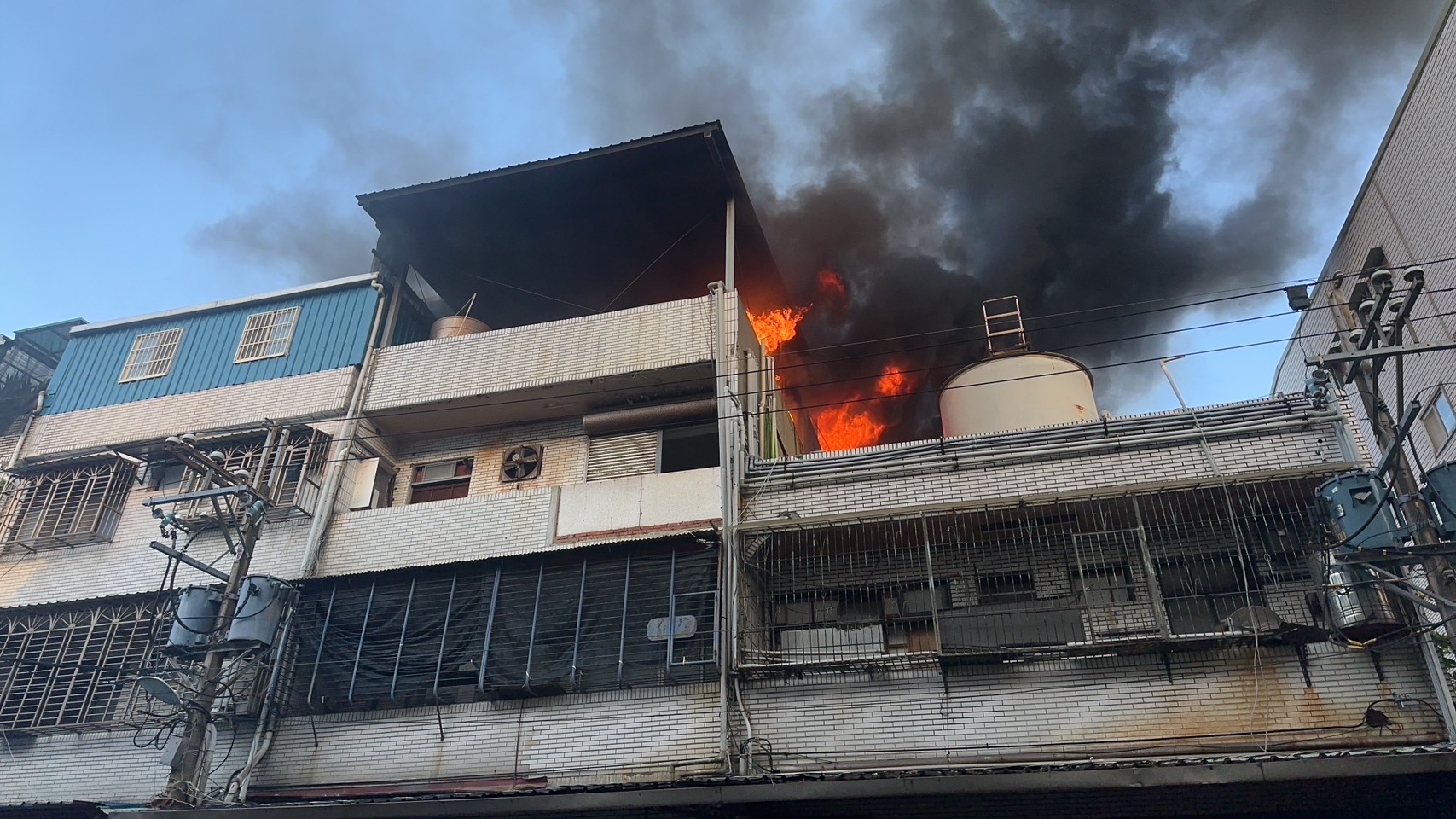 新北市三峽一處廠房4樓鐵皮屋發生火警竄出火舌。（圖／翻攝畫面）
