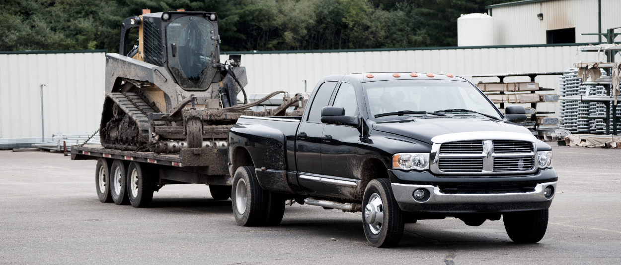 CURT class 5 hitch on Ram truck with skid steer on flatbed trailer CURT class 5 hitch on Ram truck with skid steer on flatbed trailer