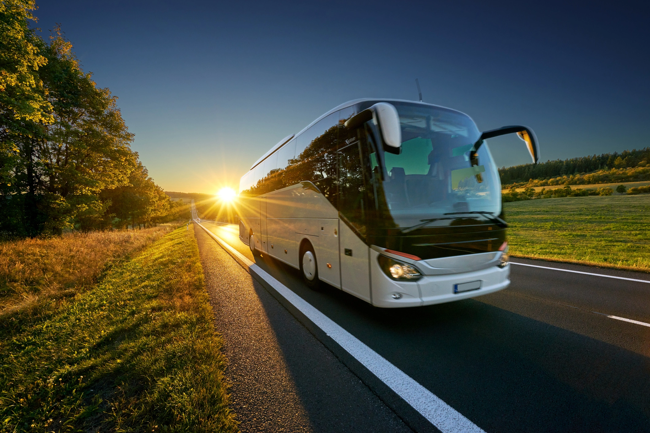Luxury bus driving at sunset