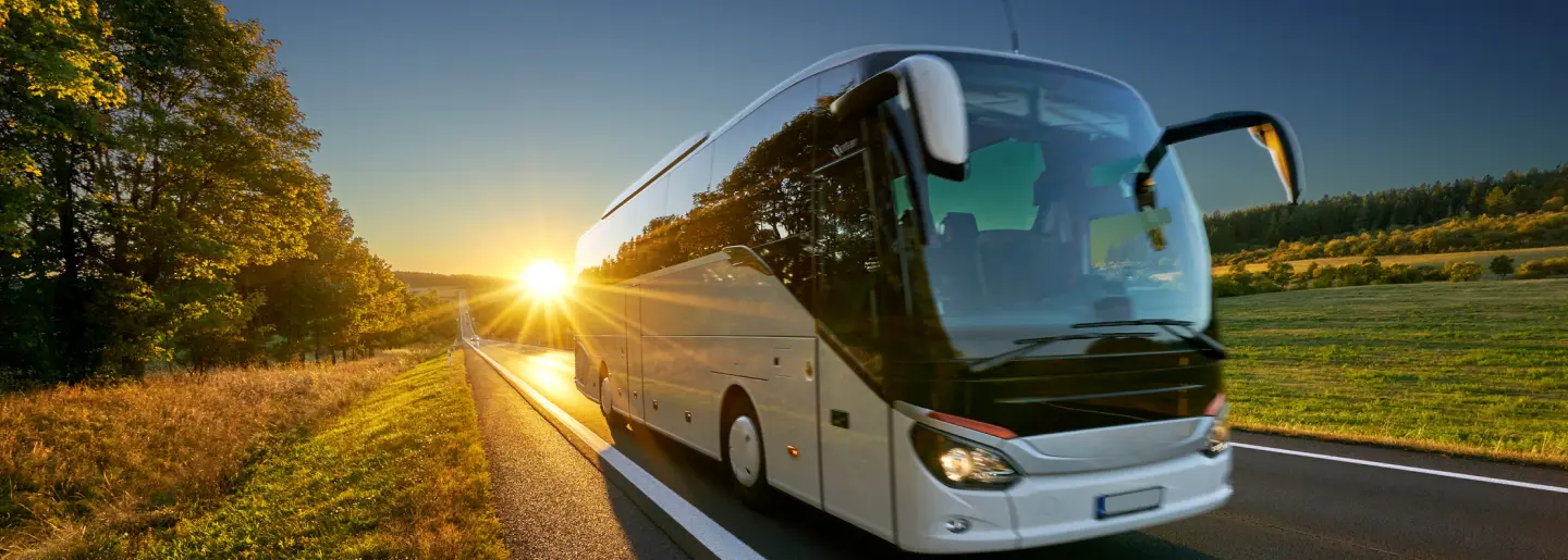 Luxury bus driving at sunset