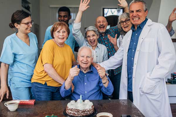 A group of seniors celebrate a resident's birthday.