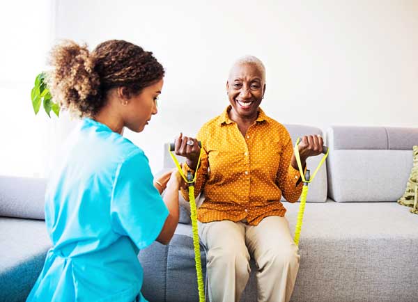 A senior woman exercises during physical therapy.