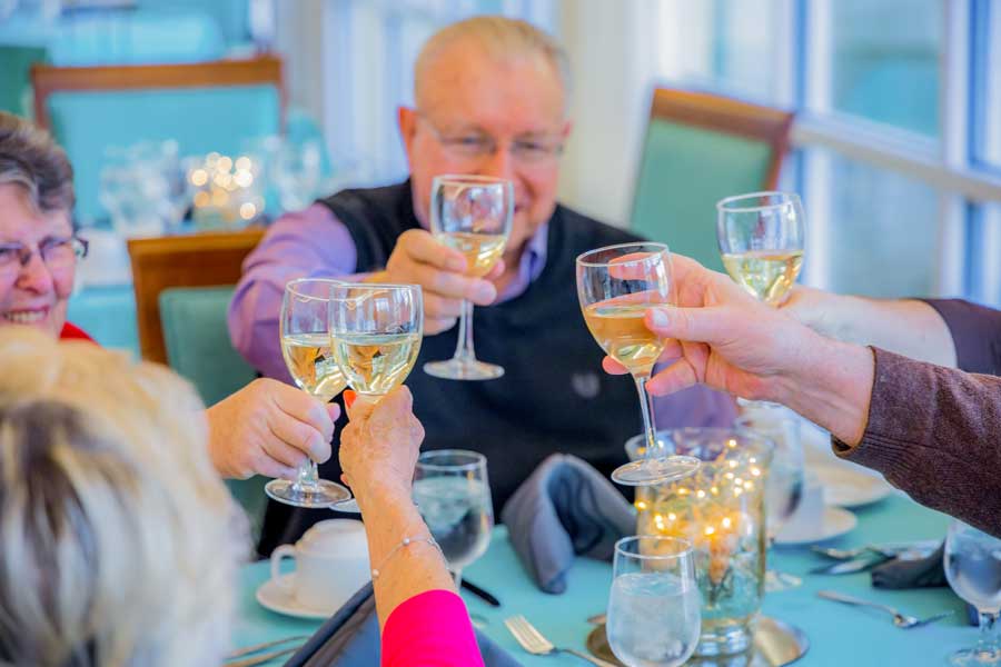 Senior residents toast while dining at Cypress Village.