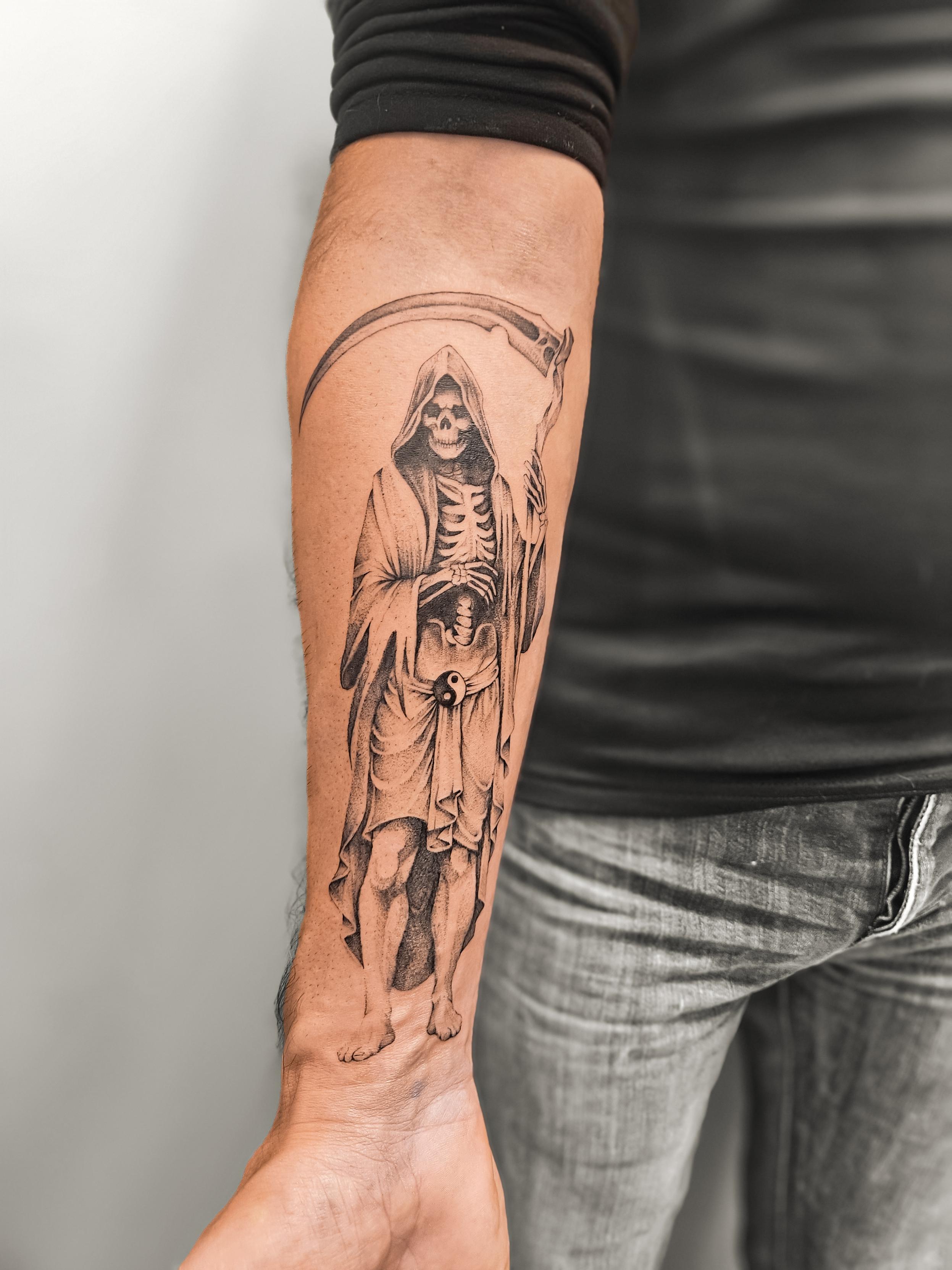 Ce tatouage représente la Faucheuse (Grim Reaper) dans un style réaliste exécuté en fine-line. La figure squelettique porte…