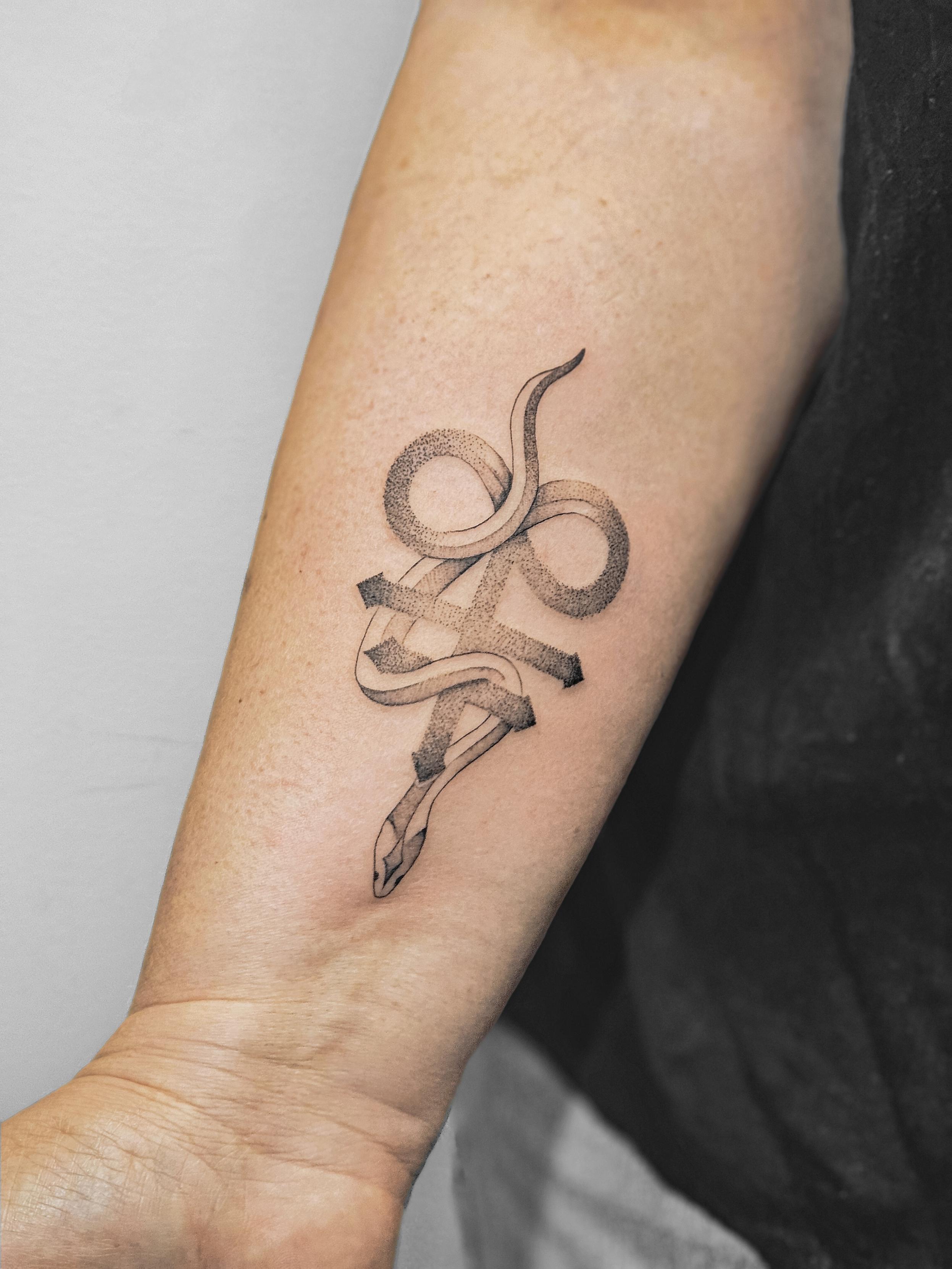 Ce tatouage présente un serpent stylisé en fine-line et blackwork, situé sur l'avant-bras. Le serpent est représenté de…
