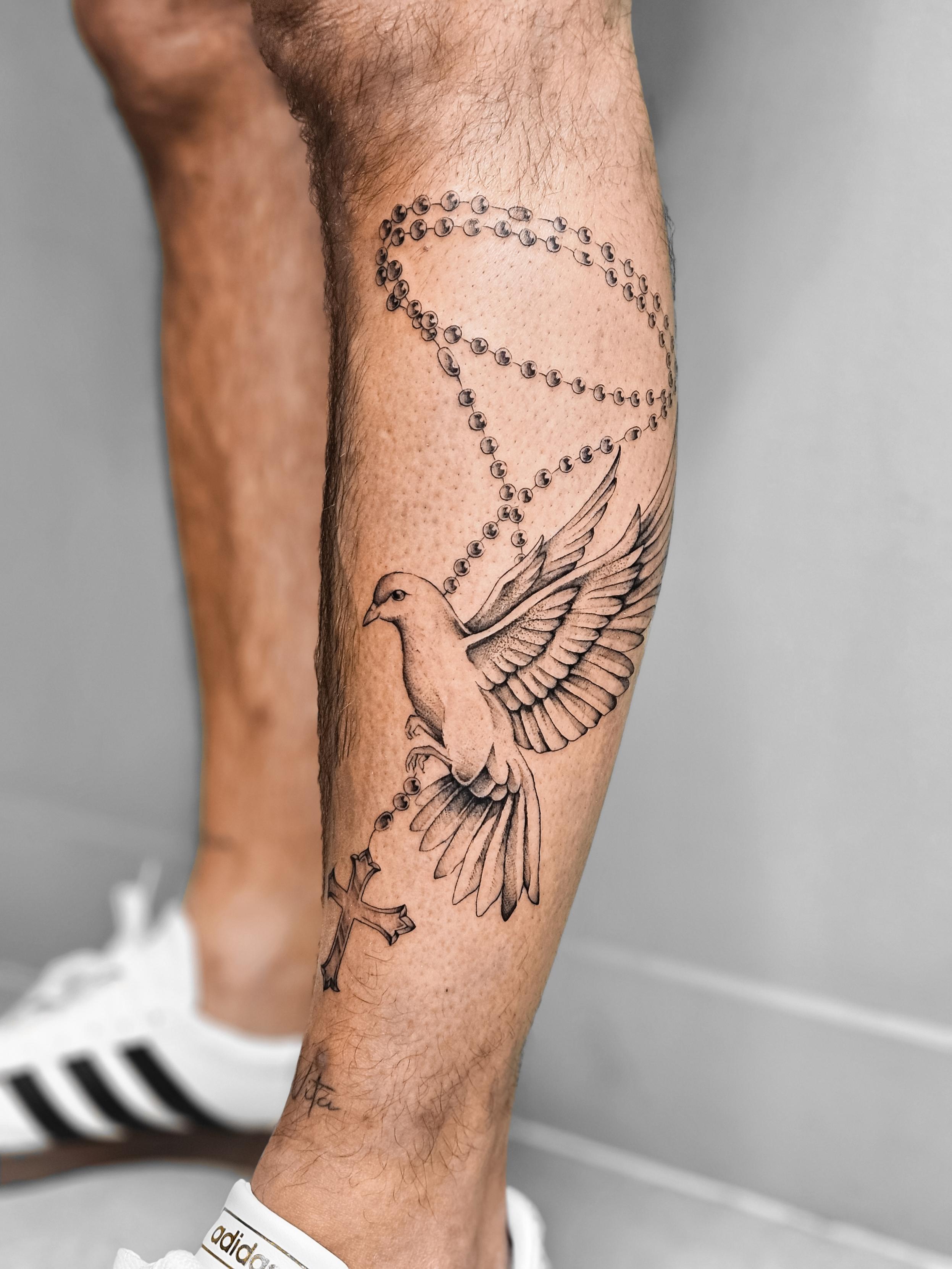 Ce tatouage situé sur le mollet représente une colombe aux ailes déployées dans un style fine-line délicat et précis.…