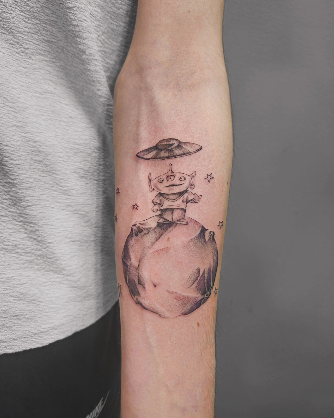 Ce tatouage représente une scène extraterrestre charmante et fantaisiste située sur l'avant-bras. L'élément central est un…
