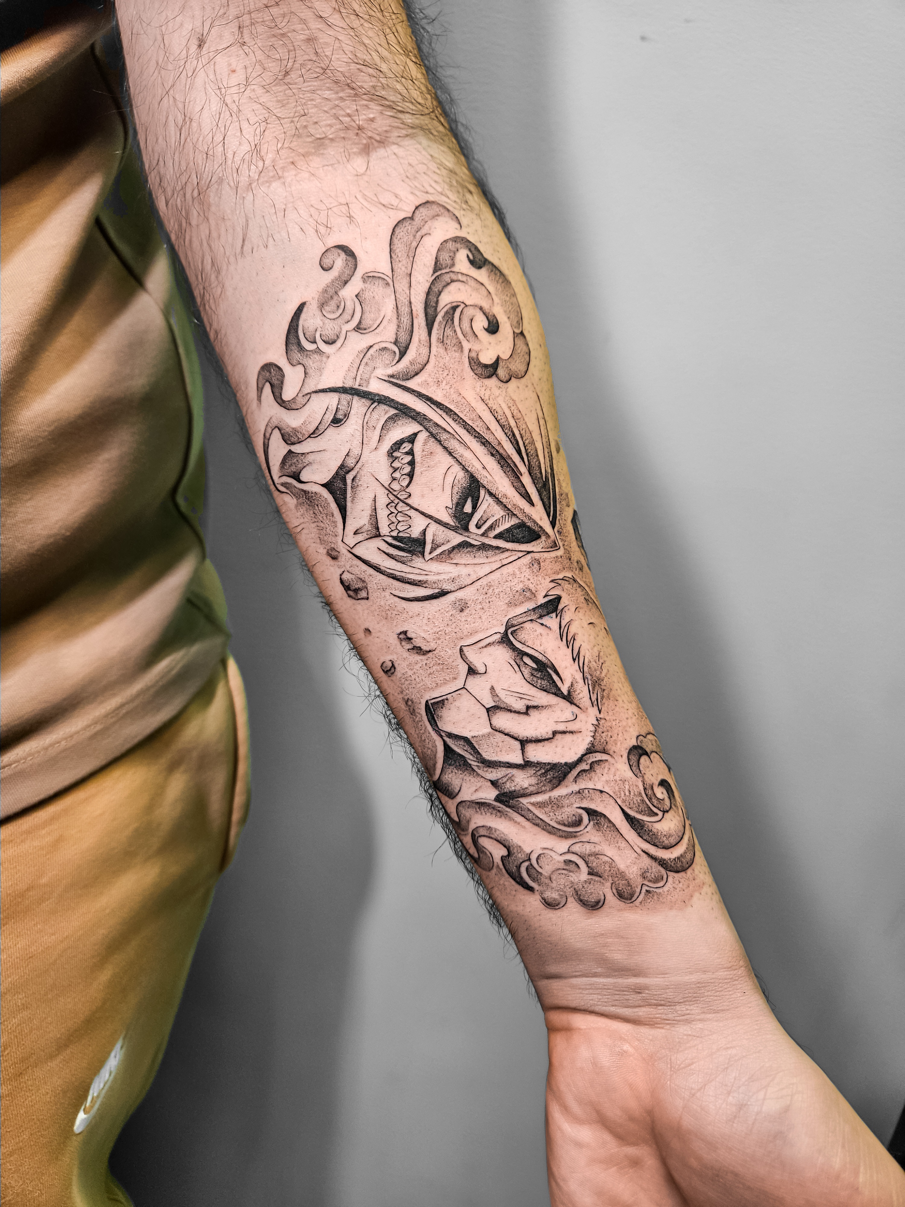 Ce tatouage réaliste en noir et gris s'étend sur l'avant-bras et présente une composition artistique complexe centrée autour…