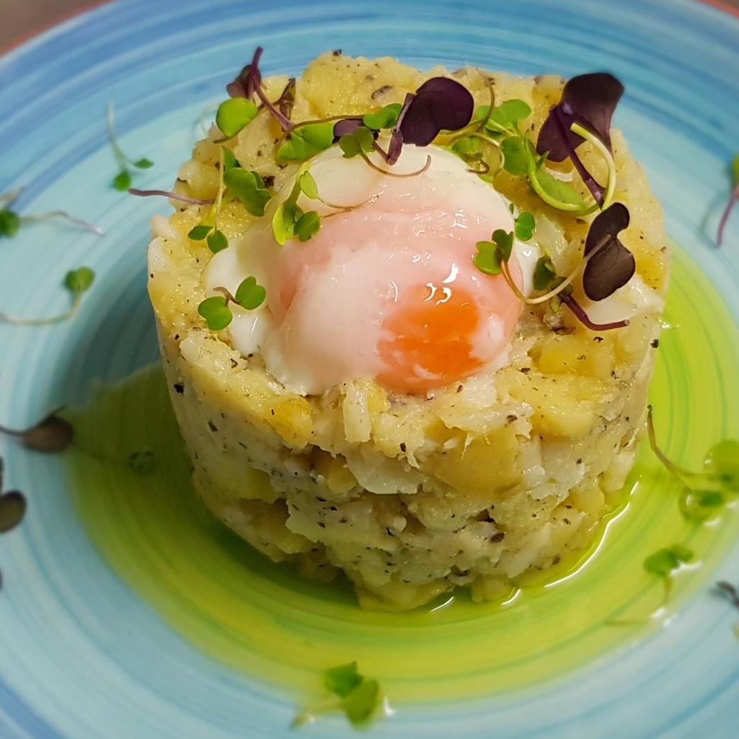 Potatoes confit in olive oil with cod, black truffle, and low-temperature free-range eggs