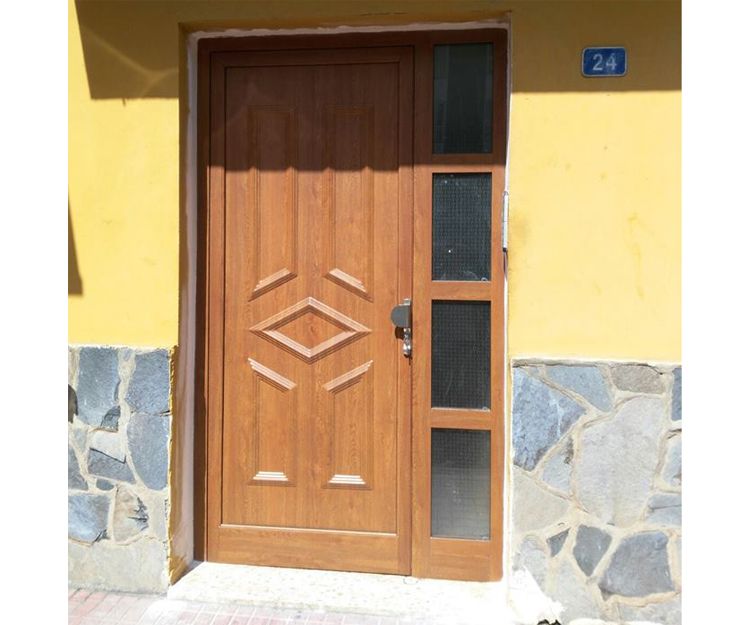 Puerta de entrada con panel ciego y un fijo con cuatro cristales