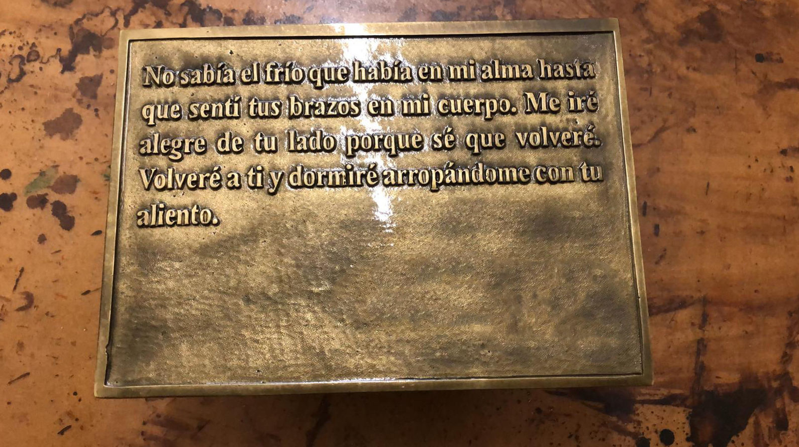 Placa con texto personalizado en relieve fundida en latón y acabada en tono dorado