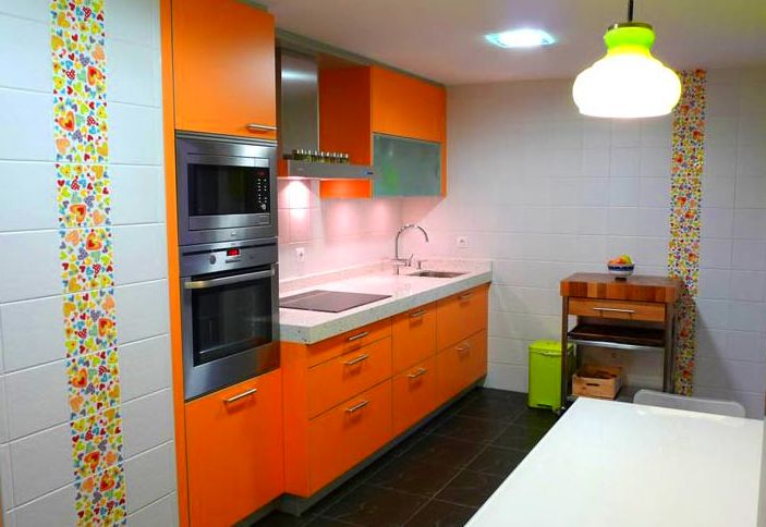 Cocina de diseño moderno color naranja y aluminio.