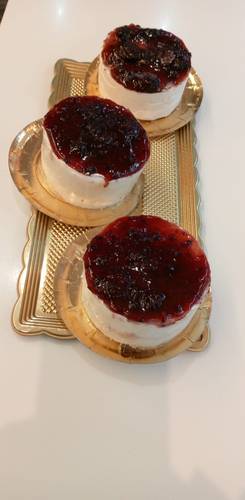 Postre de queso con mermelada de fresa y aŕándanos