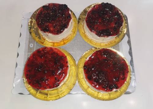 Postre de queso con mermelada de fresa y aŕándanos