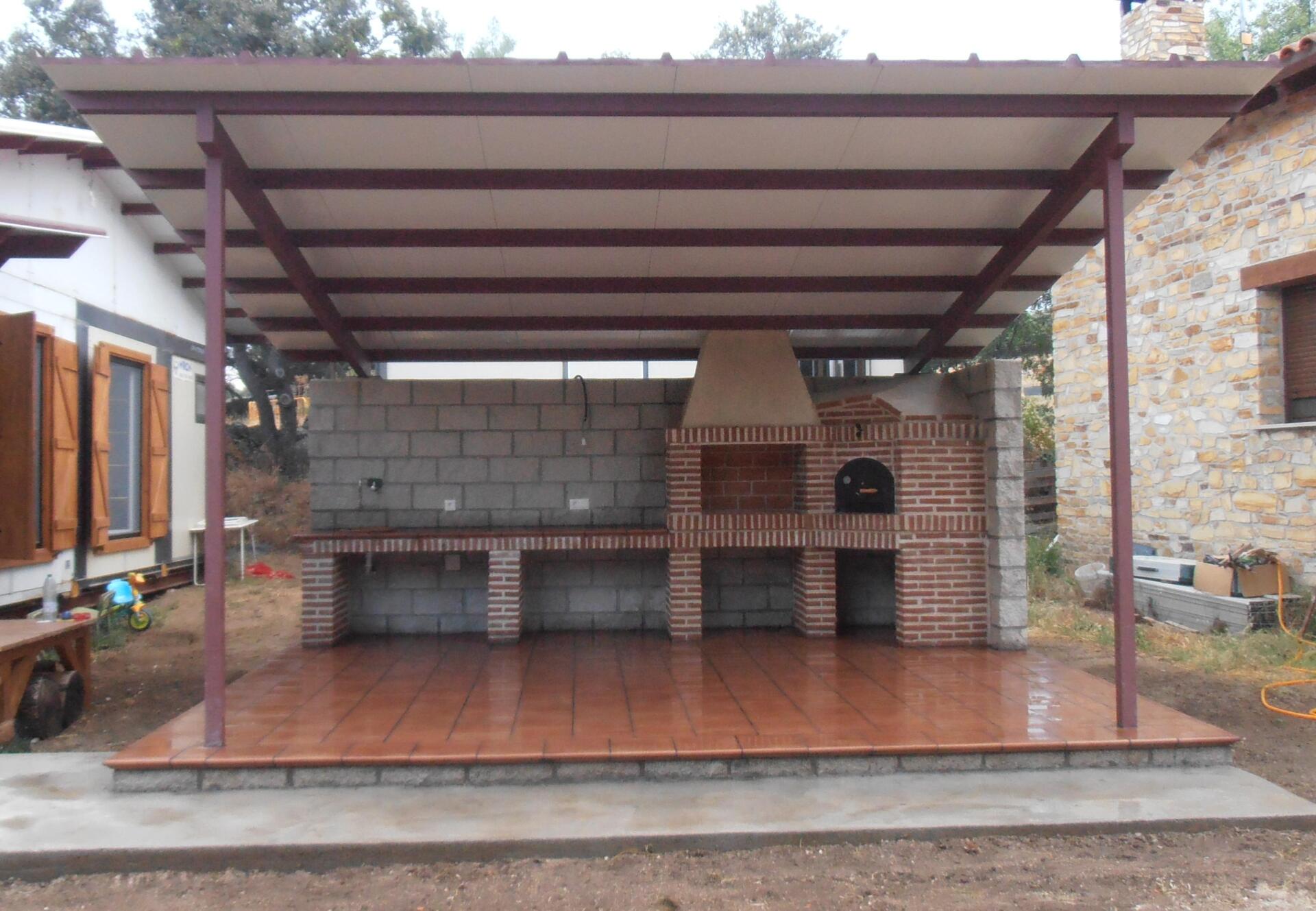 Barbacoa con horno en rincon, encimera con pila y techo de chapa.