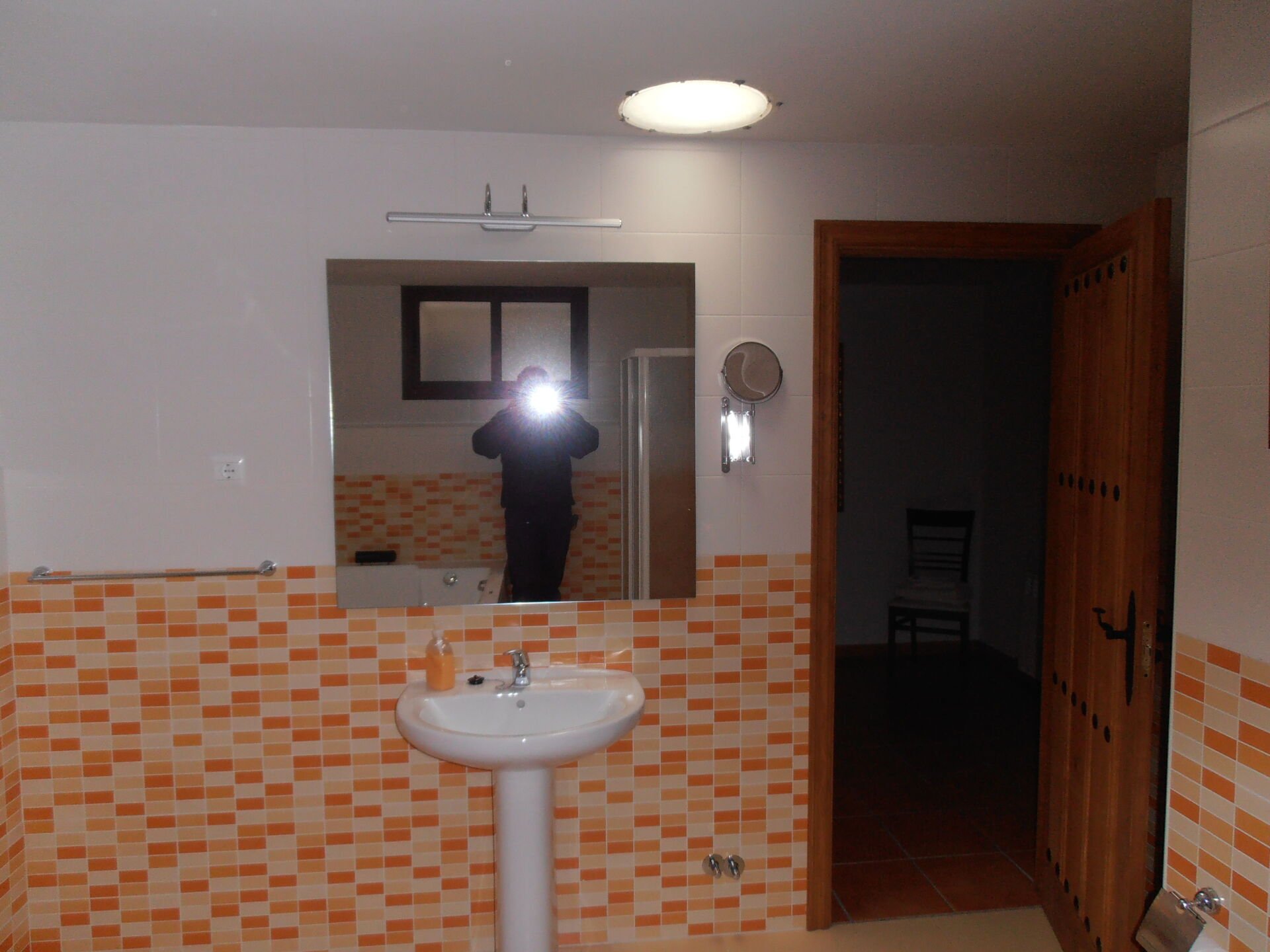 Baño en semisotano con tubo luz sobre el lavabo.