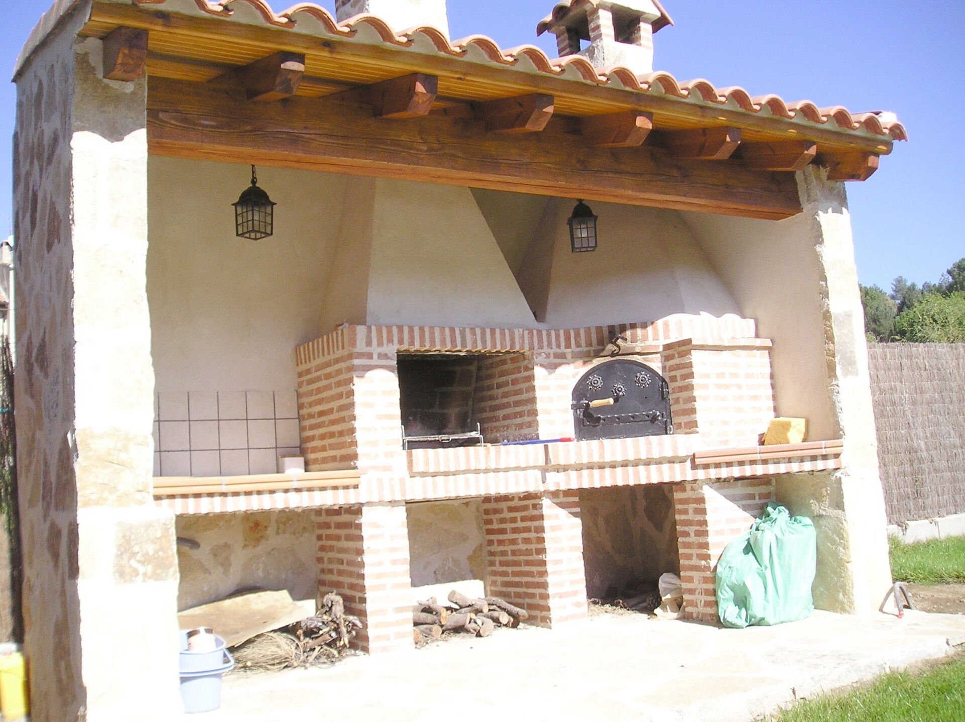 Horno en rincón con barbacoa adosada y encimera con fregadero