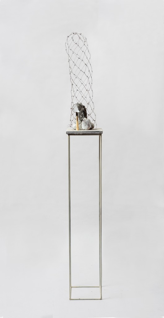 “A noiva”, 2016, pedra, lente, rede de metal, casa de abelha e ladrilho hidráulico, 152 x 41 x 41 cm