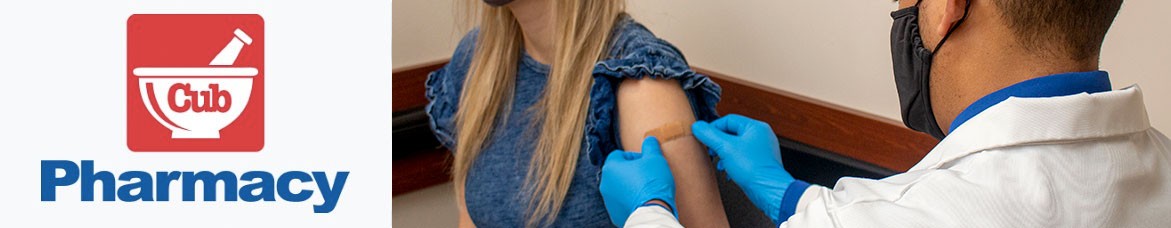 Pharmacist applying a band aid after giving a woman a vaccine