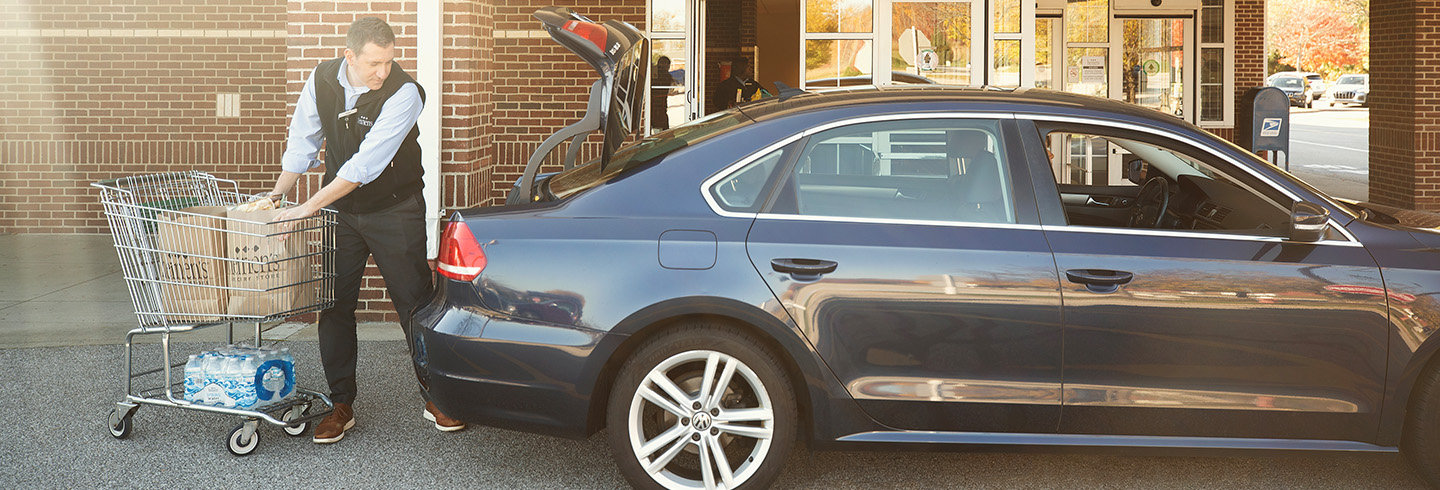 Associate loading groceries into a car
