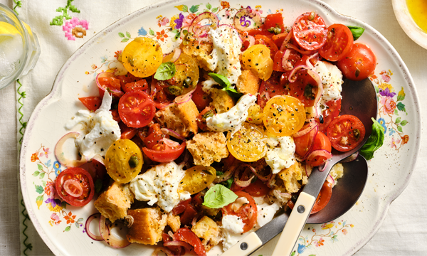 A salad made up of mozzarella, ripe tomatoes, capers, stale ciabatta as croutons and basil leaves