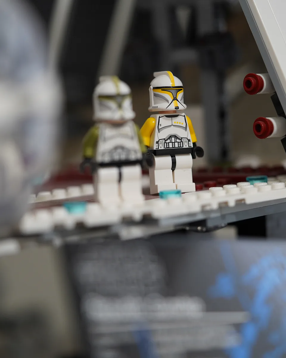 Two Lego clone trooper figures standing on the ramp of a model ship, photographed close with the background thrown out of focus