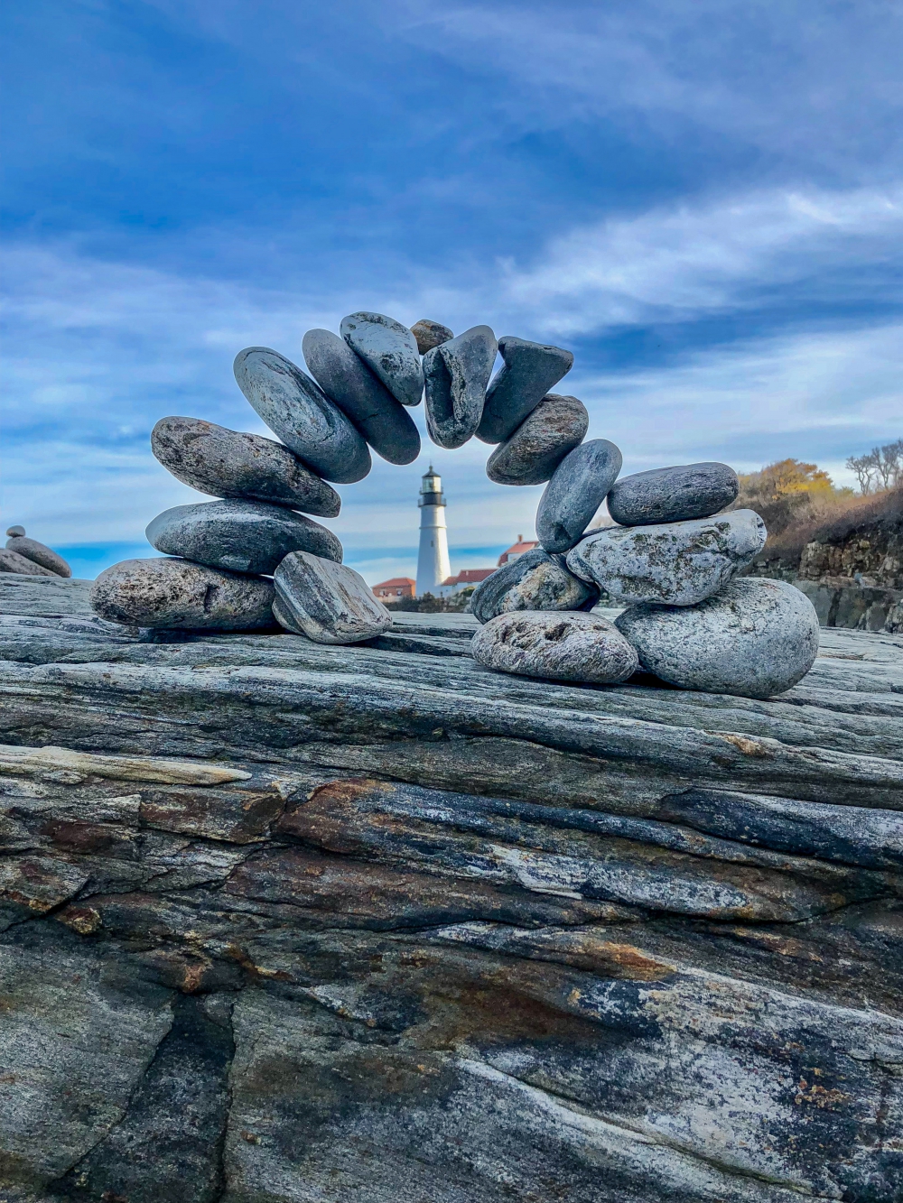 a lighthouse framed through a stone arch