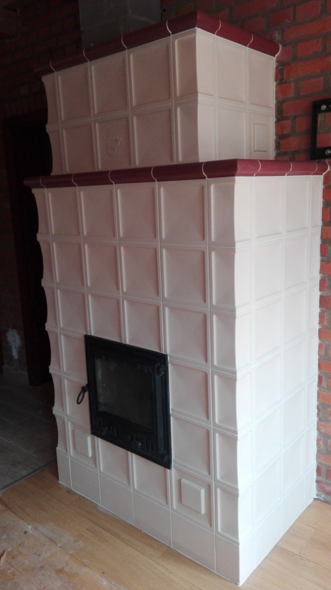 Moderner kachelofen mit ziegelwand - Moderner Kachelofen auf einer Backsteinmauer gebaut