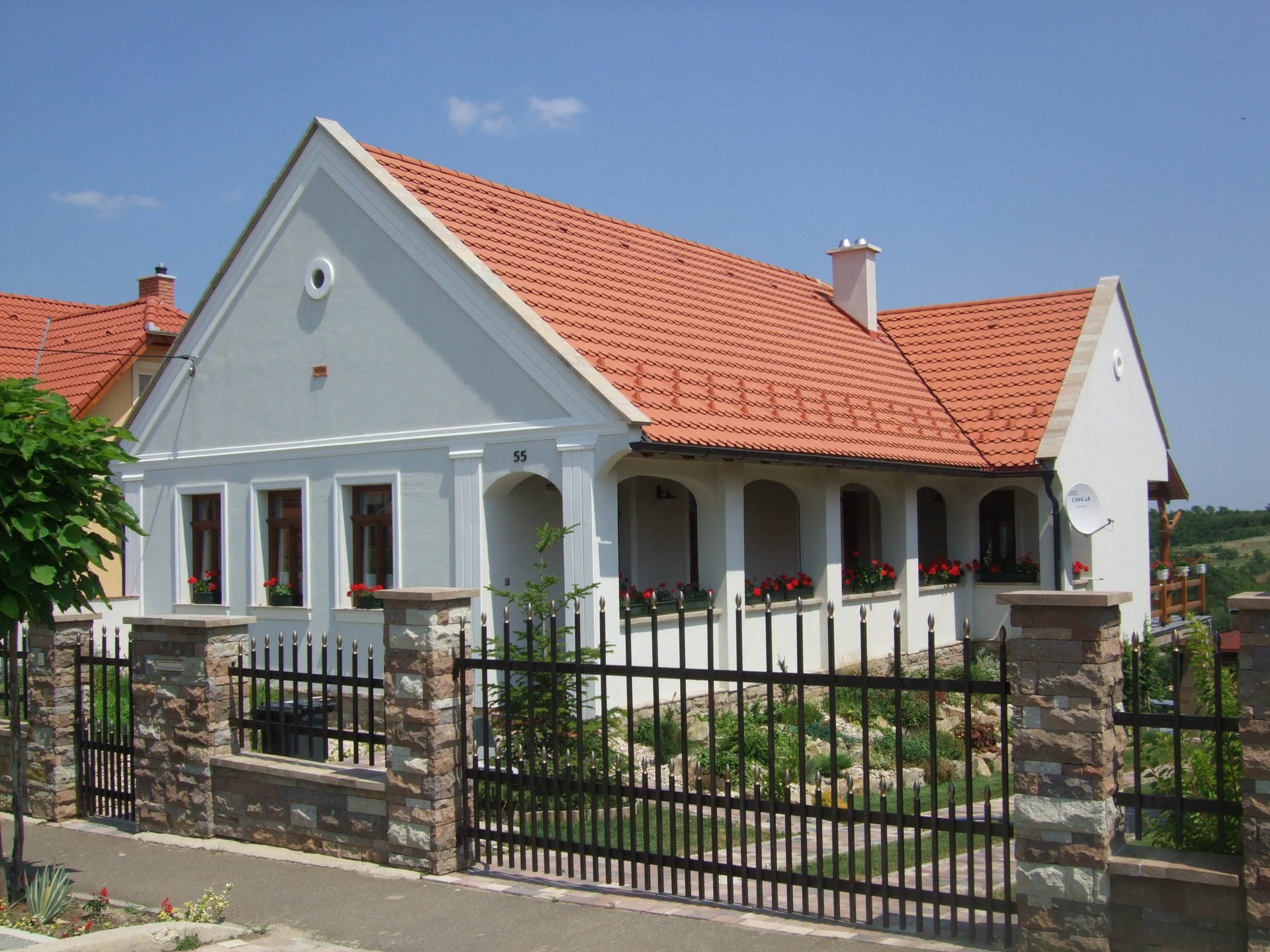 Traditionelles Bauernhaus mit Ziegeldach und schmiedeeisernem Zaun - Traditionelles Bauernhaus mit Ziegeldach und schmiedeeisernem Zaun