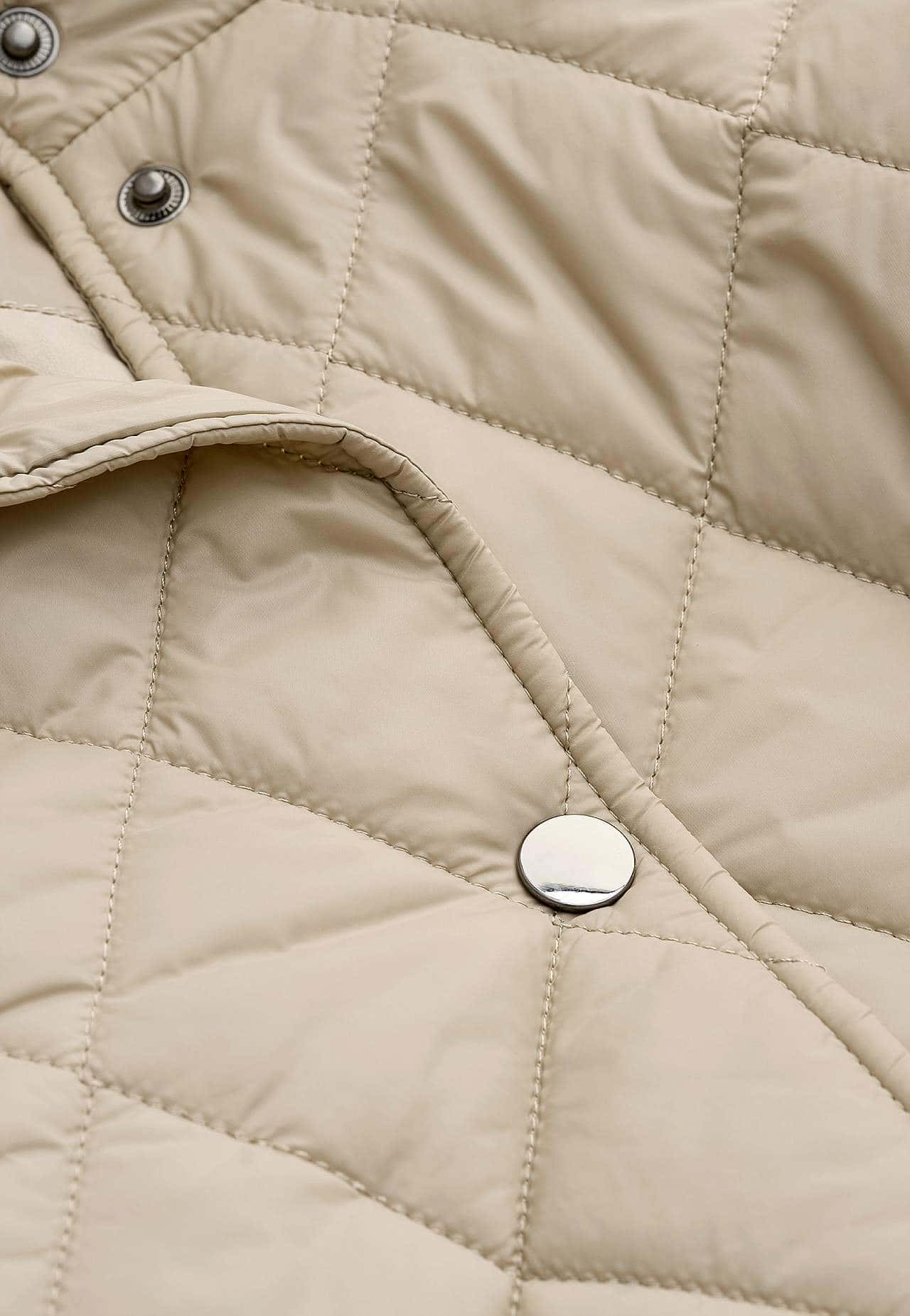 Beige quiltad jacka med tryckknappar