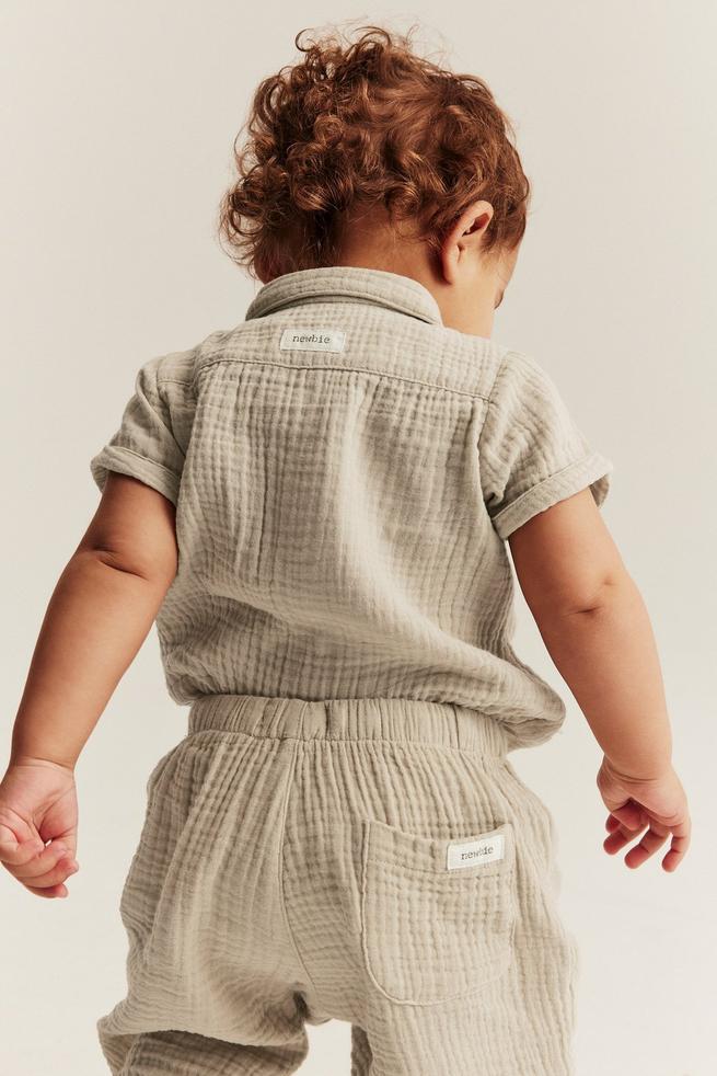 Beige kortärmad babybody med ficka