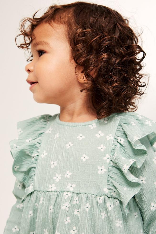Ljusgrön babyklänning med volang
