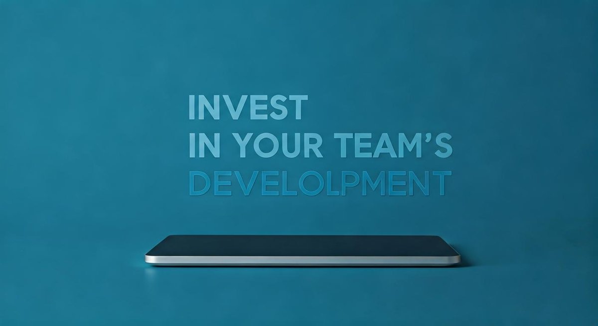 Diverse team collaboratively working on laptops in a bright, modern office. Focus on teamwork and professional growth.