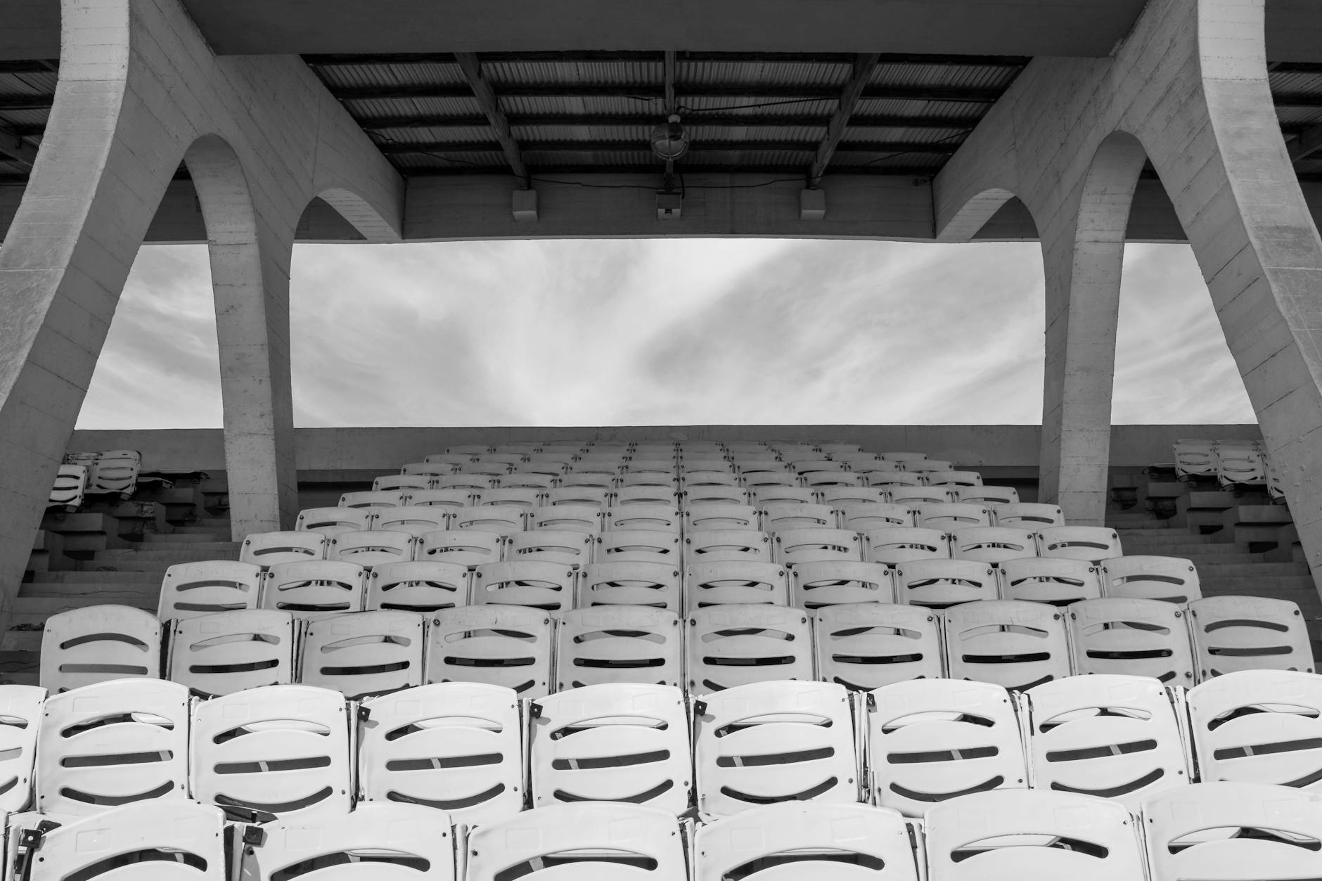 Monochrome capture of empty stadium seats in Accra's urban architecture.