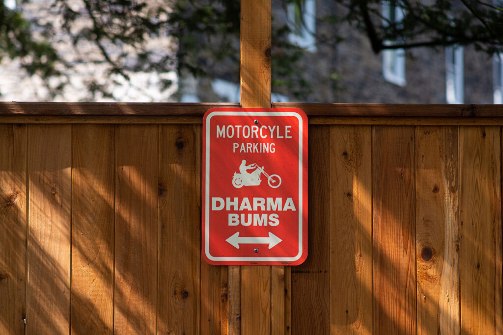 A red Dharma Bums motorcycle parking sign