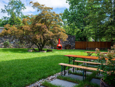 Courtyard and red stove next to picnic tables