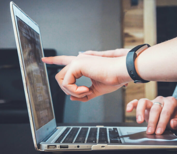 Pointing finger on laptop screen