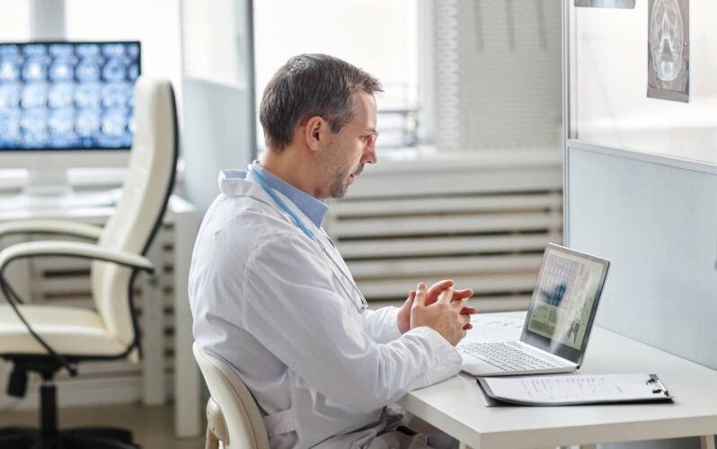 A healthcare professional working on his laptop