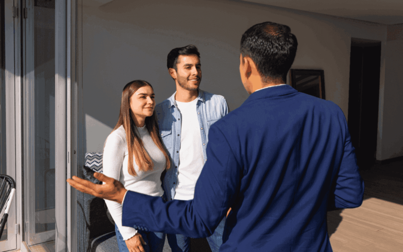 A realtor showing a couple around a vacant home