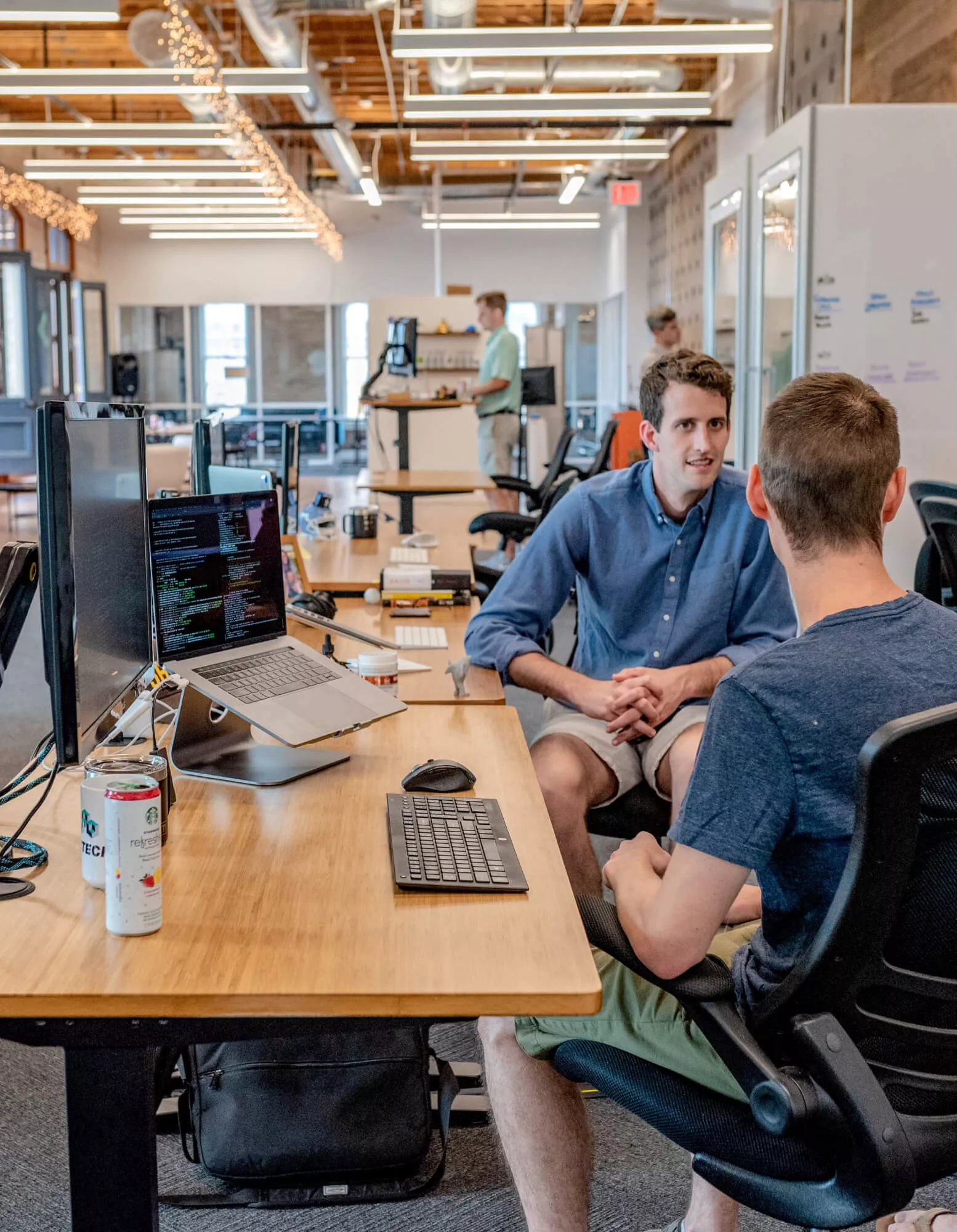 Office workers talking to each other in an open-concept space