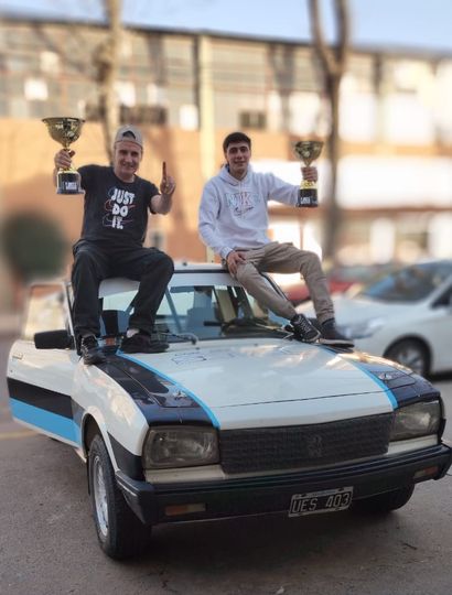 Los juninenses Federico y Sergio Gómez festejando sobre el techo de su Peugeot 404.