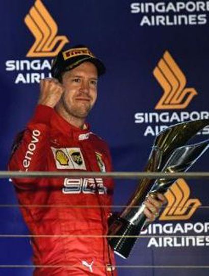 El alemán Sebastian Vettel ganó con la Ferrari y festeja en el podio.