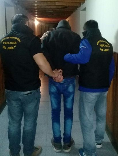 Personal policial, ingresando a la Seccional al menor imputado de extorsión.