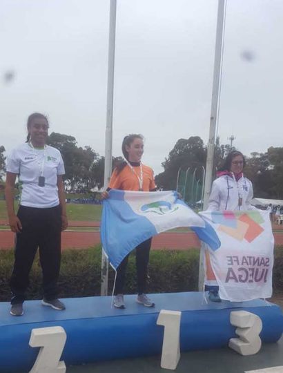 Naomi Sampaio  en el podio (izquierda), junto a quienes ganaron la medalla de oro (centro) y la de bronce.