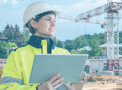 bauarbeiterin mit tablet auf einer baustelle