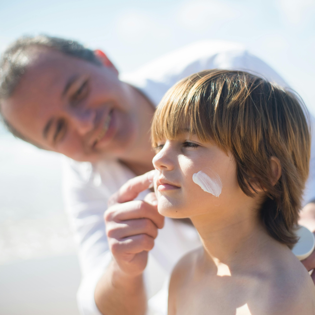 papà che spalma la crema al figlio