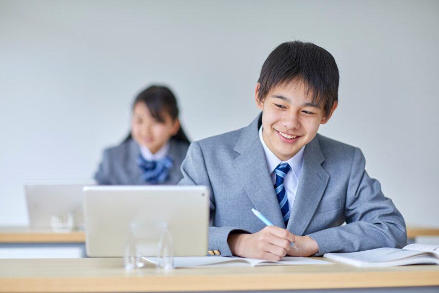 タブレットとノートで学ぶ中学生