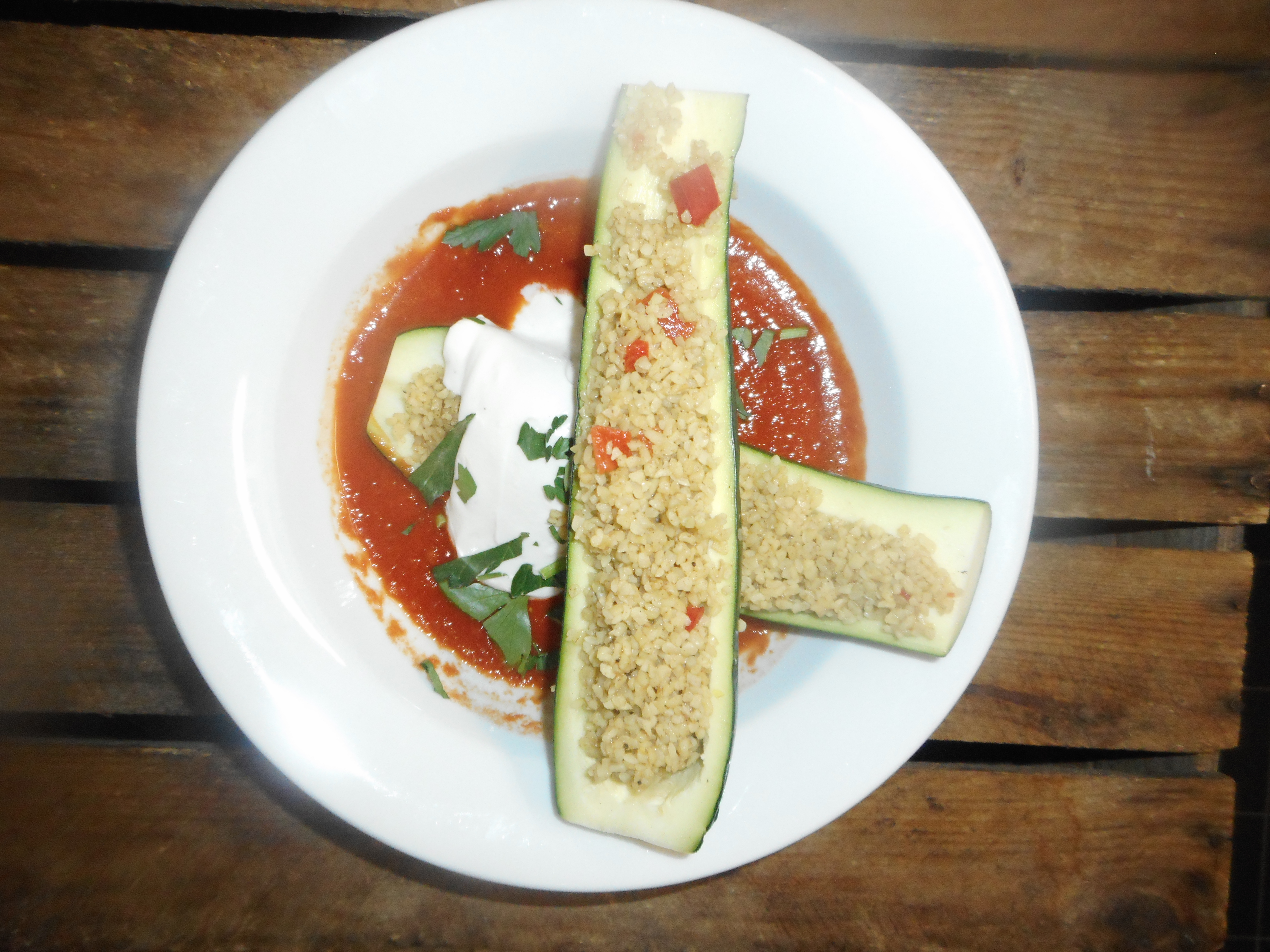 «Gefüllte Zucchetti», mit Bulgur & veganem, Frischkäse auf Tomatencoulis, Menüsalat