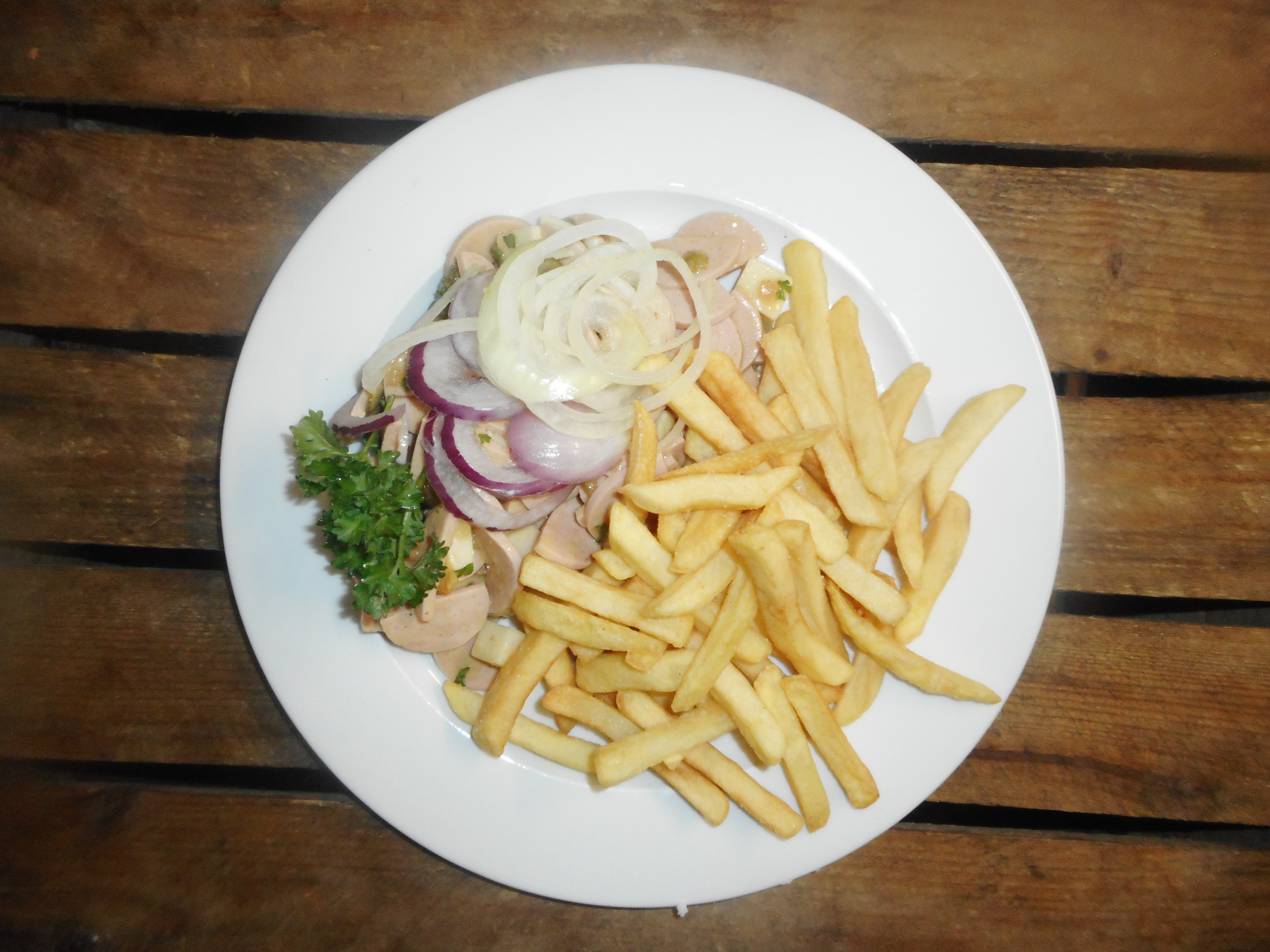 «Wurst-Gruyérekäsesalat», mit Essiggurken & Zwiebeln, Pommes frites, Menüsalat
